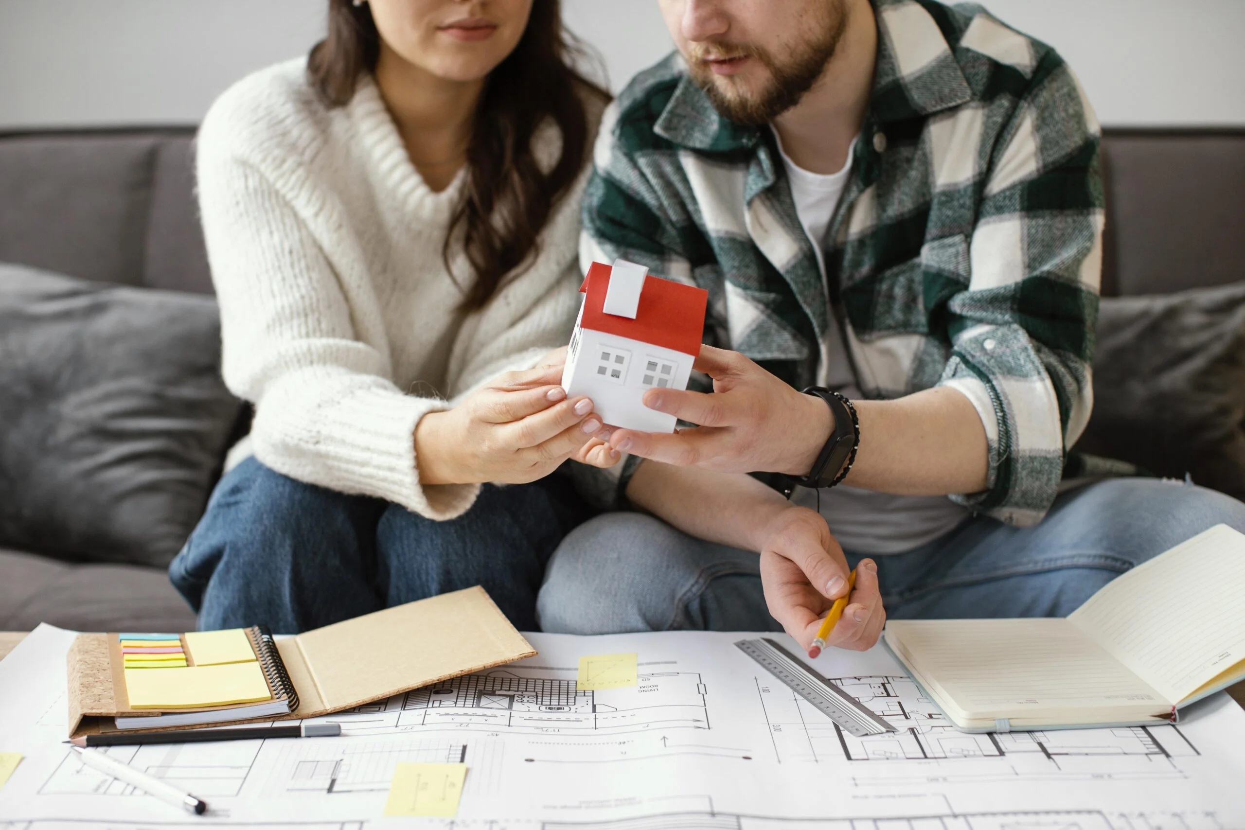 couple holding small house close up scaled
